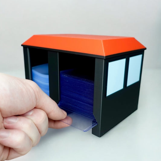 Hand holding Heady Prints 3D printed black and orange card care center with blue trading cards