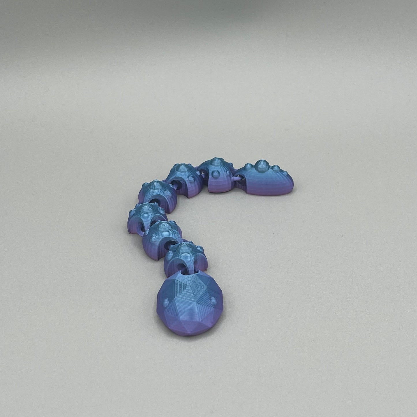 Heady Prints 3D printed blue articulated gem snake, side view