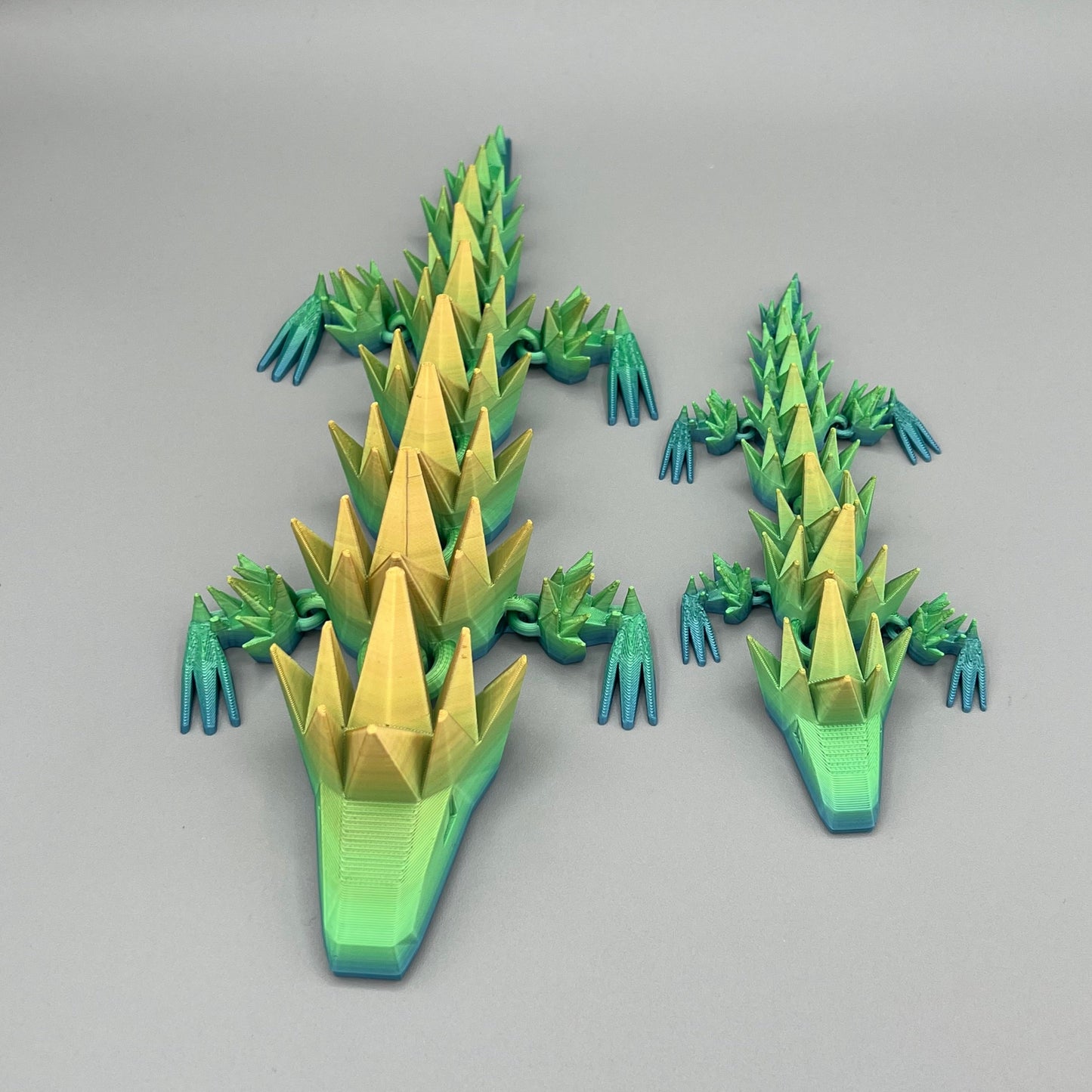 Heady Prints 3D printed green and yellow articulated spikey lizard, group shot
