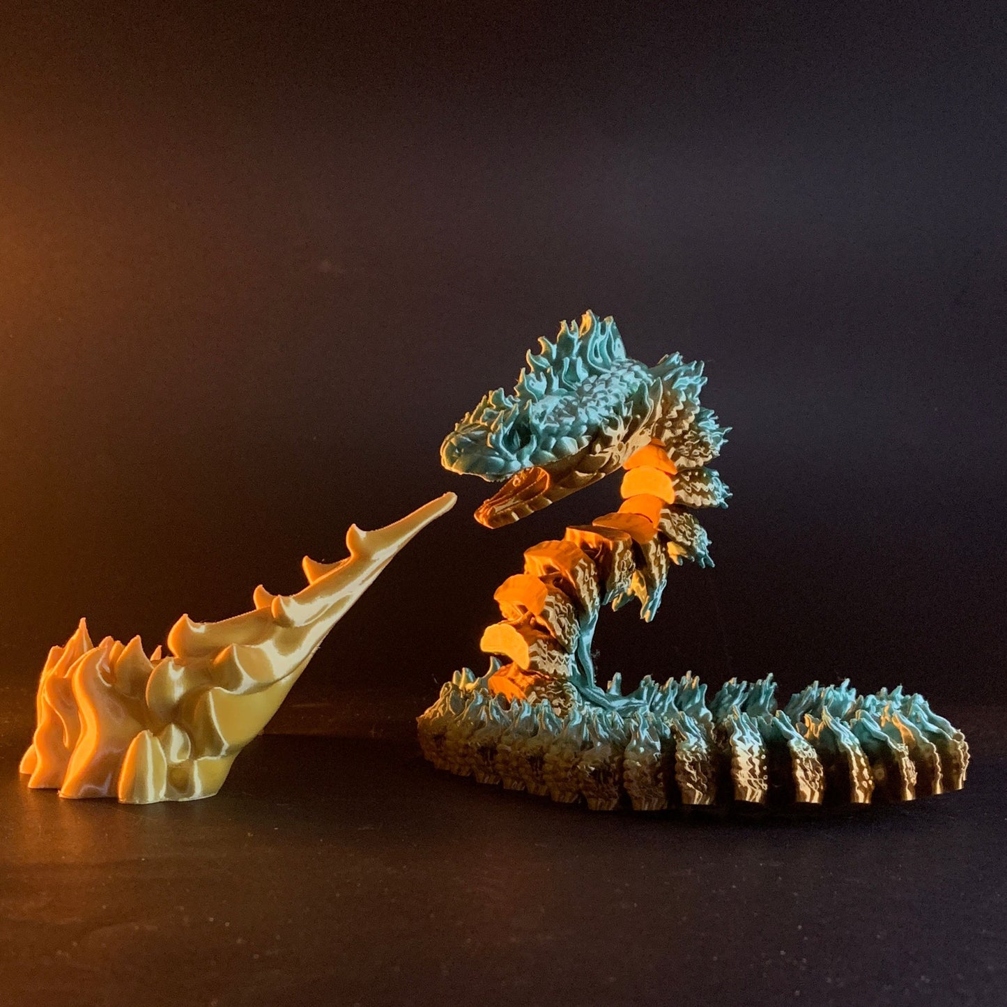 Heady Prints 3D printed teal and orange Boitata articulated snake figurine, lifestyle shot