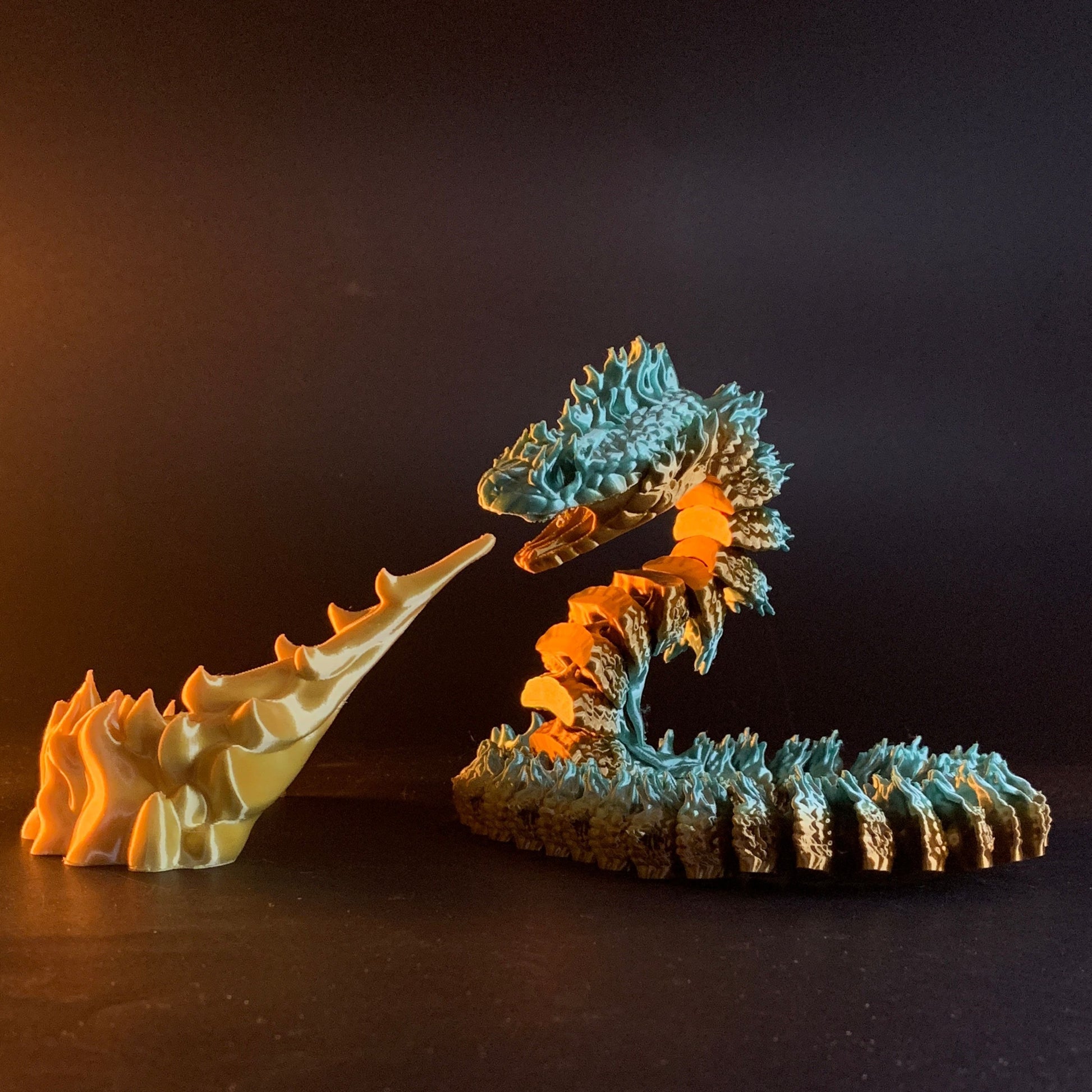 Heady Prints 3D printed teal and orange Boitata articulated snake figurine, lifestyle shot
