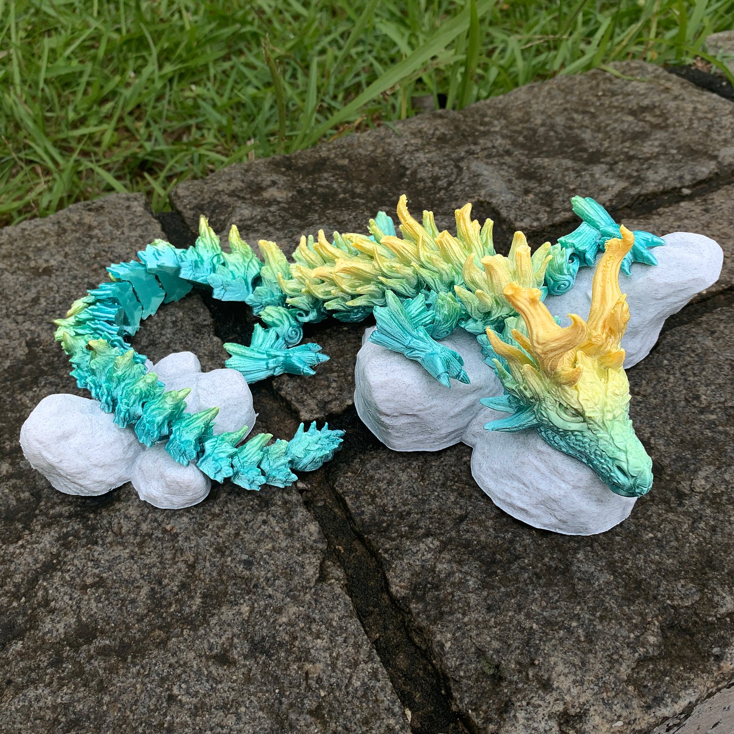 Heady Prints 3D printed Zandhros teal and yellow dragon figurine held in hand, scale reference